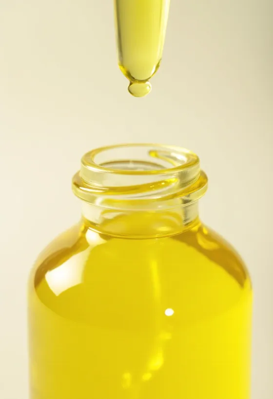 Флакон с лимонным маслом, свежие дольки лимона и цедра