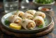 Долма в рыбе с рисовой начинкой, поданная со свежими ломтиками лимона